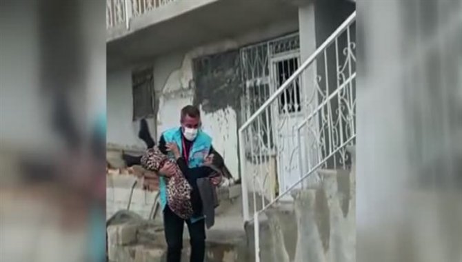 Sağlık çalışanı, yürümekte zorlanan yaşlı kadını kucağında taşıdı