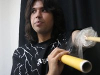 Depremde kolunun büyük bölümünü kaybeden genç, streç filmle sabitlediği bagetle bateri çalıyor